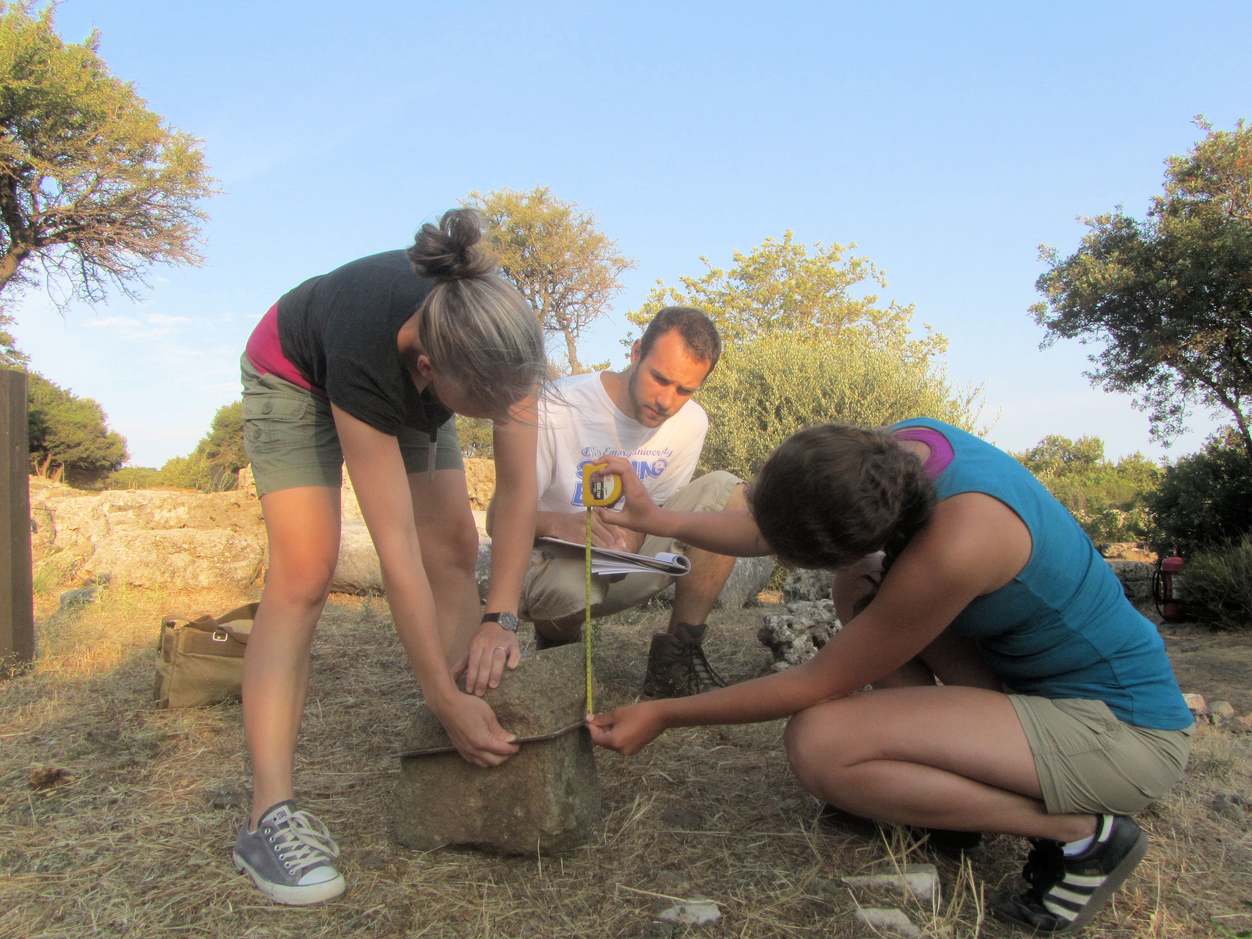 Jess, Hannah, and Zach measuring a Nike stone outside the Byzantine building.